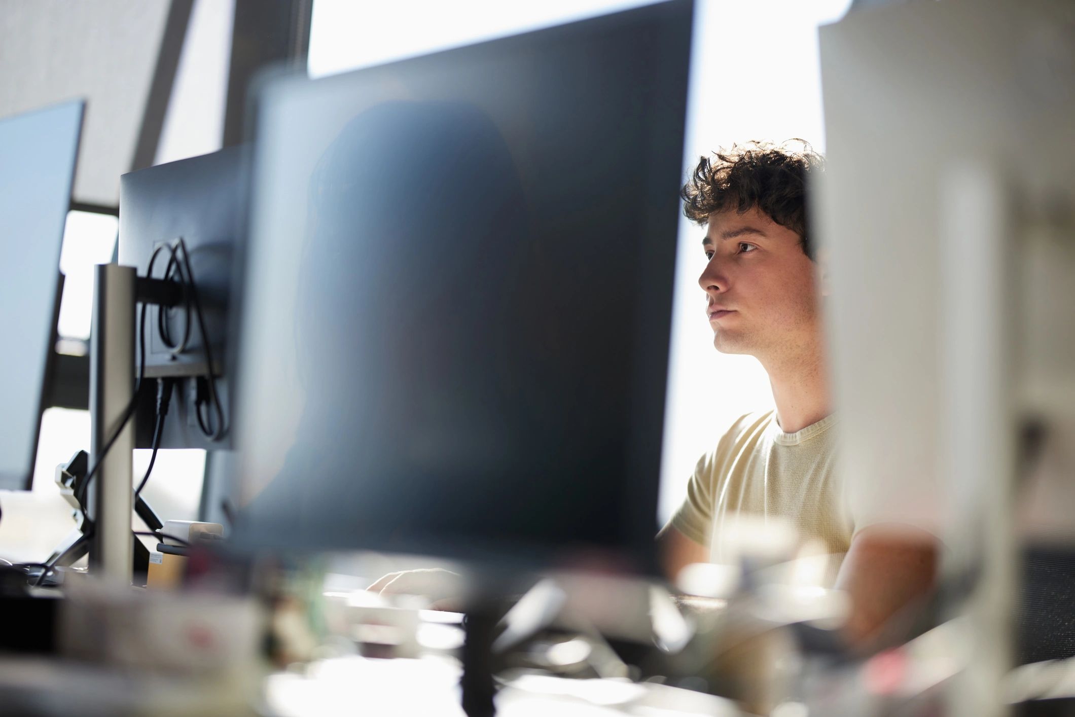 IT technician working at a desktop computer in an office